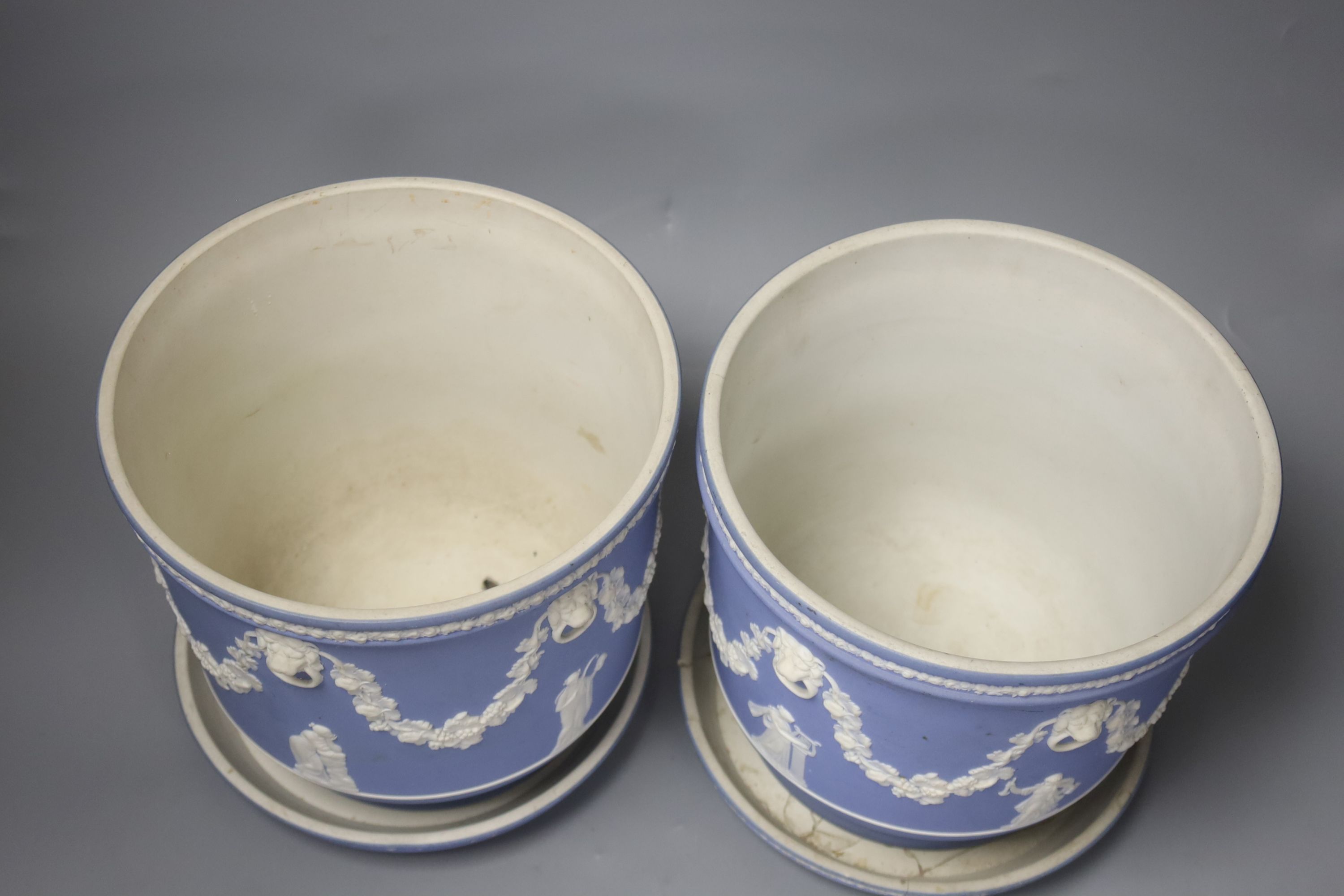 A pair of Victorian Wedgwood blue ground jasperware jardinieres and stands